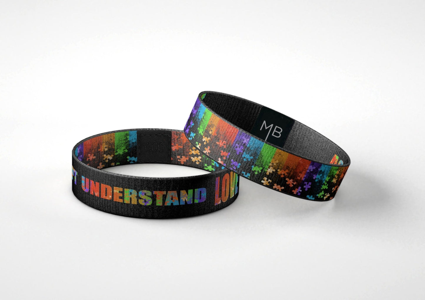 Autism Awareness Motivational Wristband Accept Understand Love Black Wristband with Rainbow Colored Puzzle Pieces laying down view